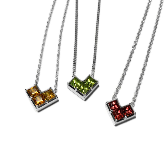Three silver Geo Heart necklaces featuring citrine, peridot and garnet.