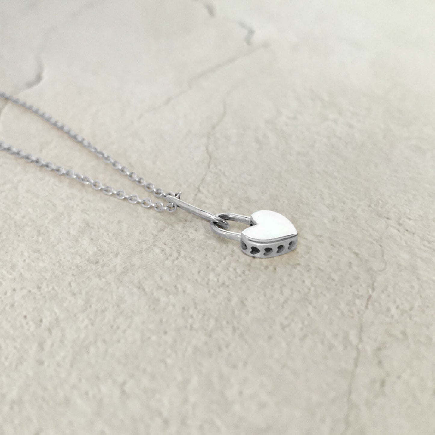 Side view of Heart Lock pendant on rolo chain