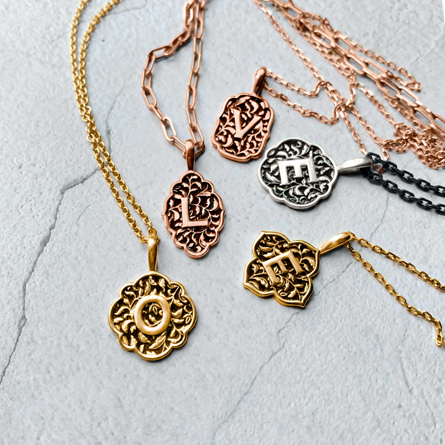 A collection of personalised Love Letter initial pendants in rose gold, yellow gold and silver 