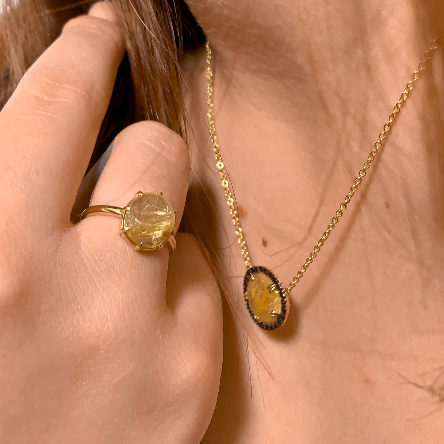Yellow gold jewellery set with golden rutile quartz worn by a model