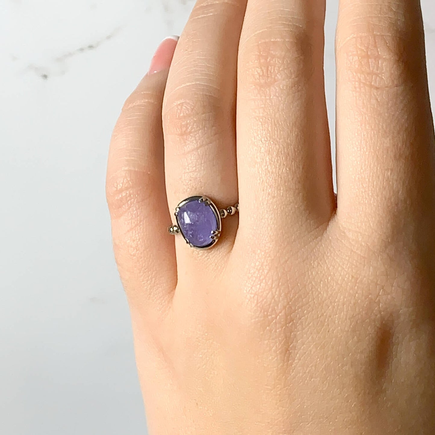 Serendipity ring with tanzanite on a hand