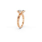 Side view of emerald cut diamond engagement ring showing connection between split bezel and side-by-side bands in rose gold 