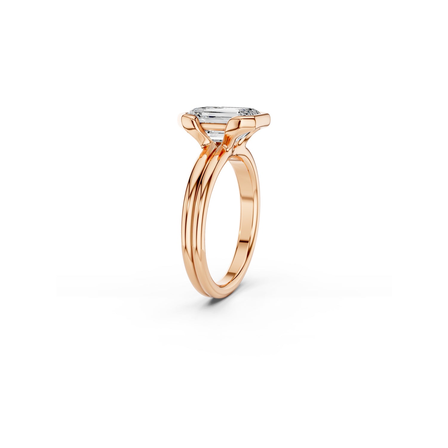 Side view of emerald cut diamond engagement ring showing connection between split bezel and side-by-side bands in rose gold 
