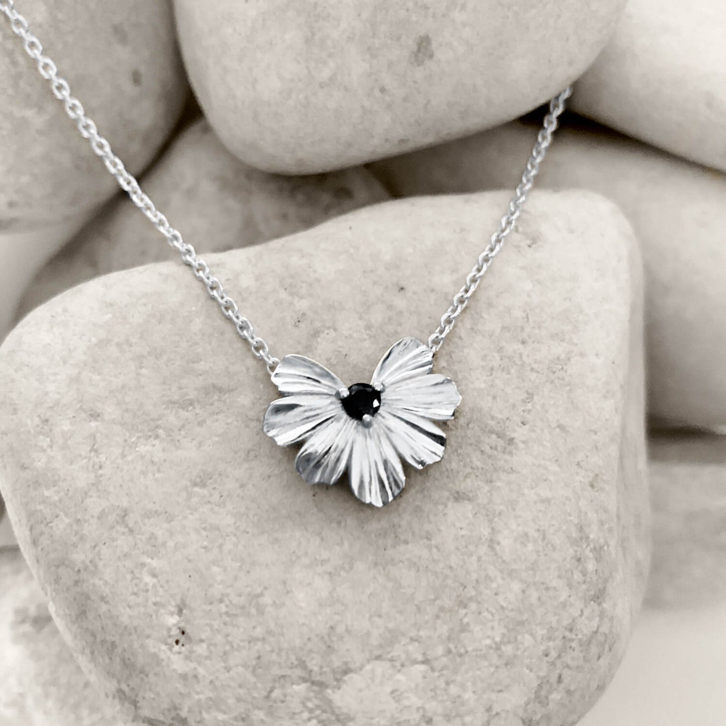 Silver floral heart shaped pendant with black moissanite on a rolo chain 