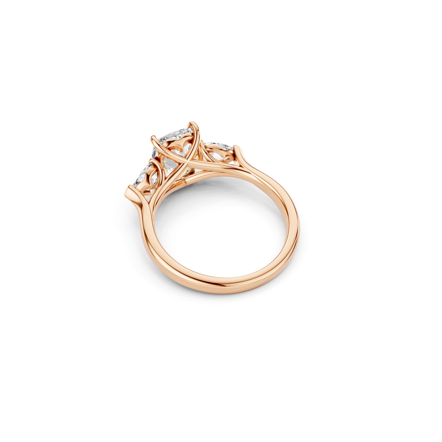 Angled side view of three stone engagement ring showing design detail in rose gold 